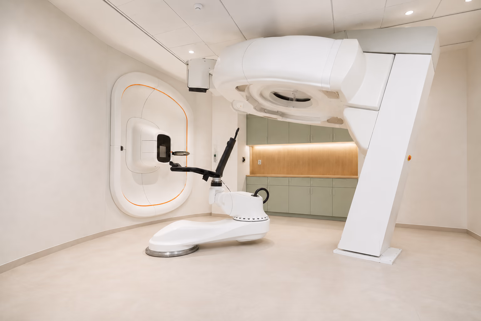 Aristion’s P-Cure room, with a fixed wall-mounted proton beam unit, robotic upright chair and raised CT scanner.
