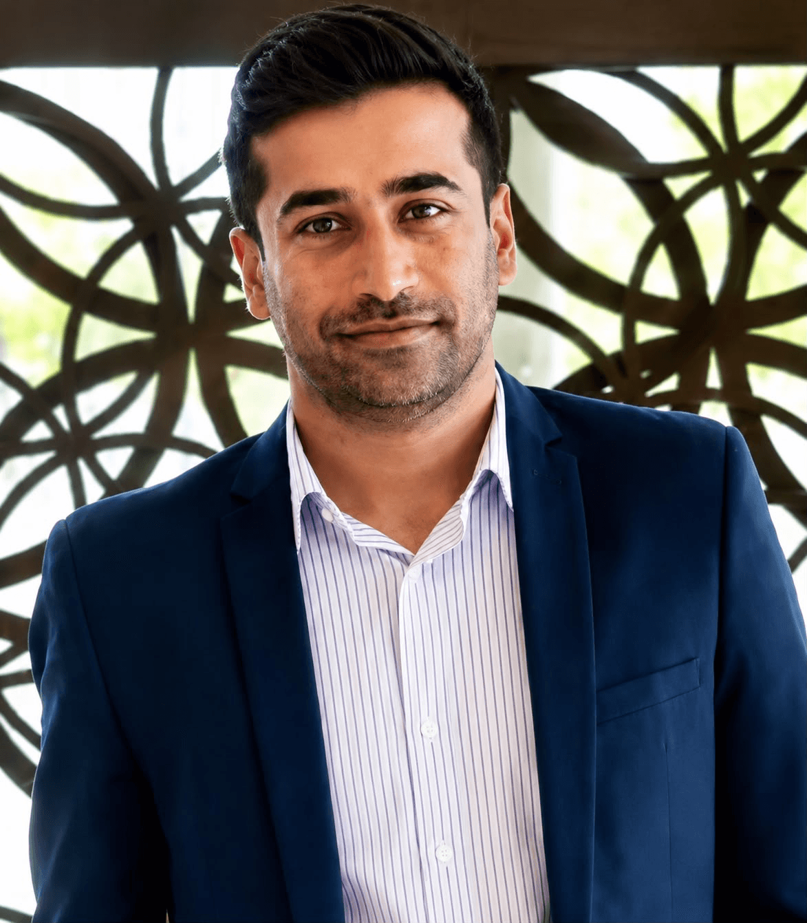 Dr. Lohith G. Reddy, wearing a navy blazer and striped shirt.