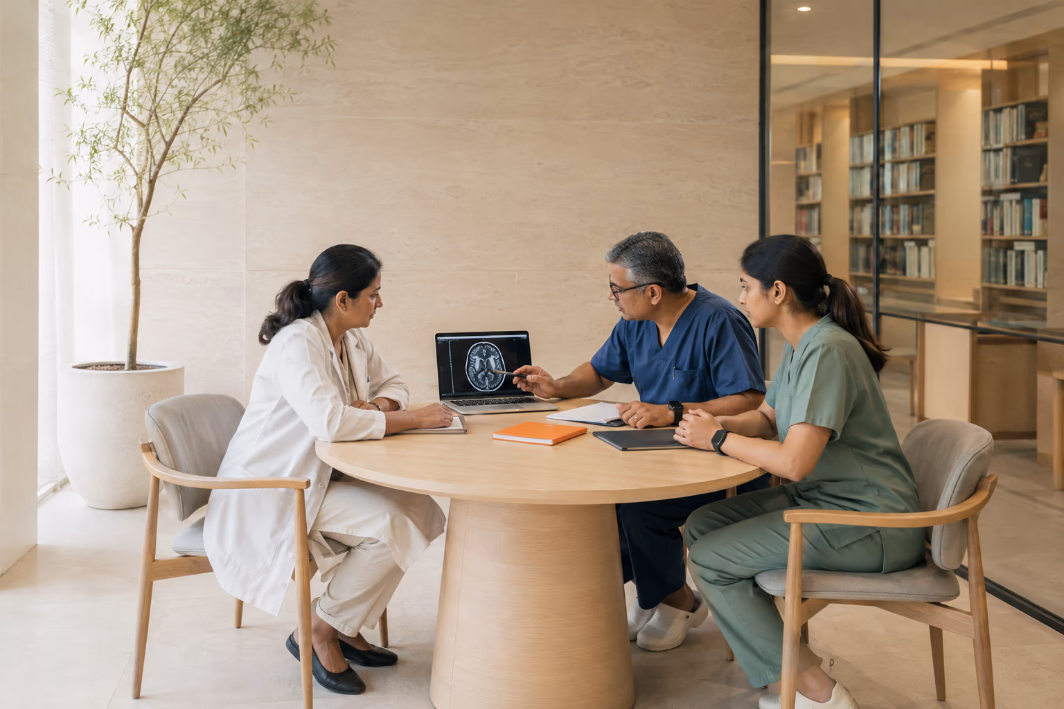 Three clinicians reviewing imaging together in a daylit consultation library.