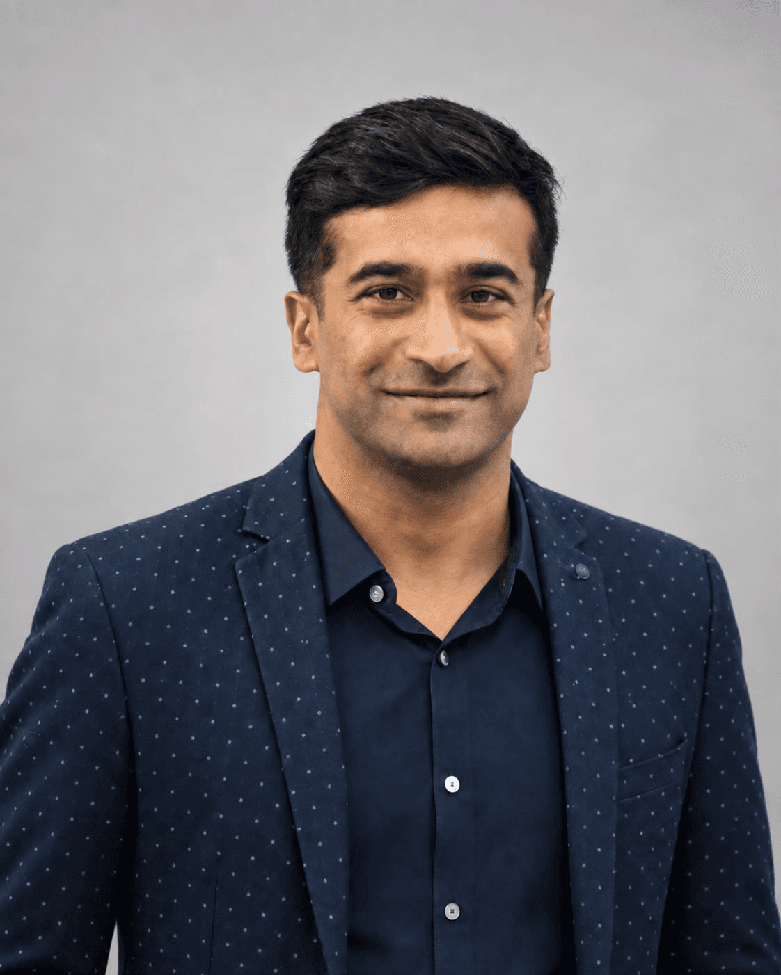 Dr. Lohith G. Reddy, wearing a navy dotted blazer over a dark shirt.