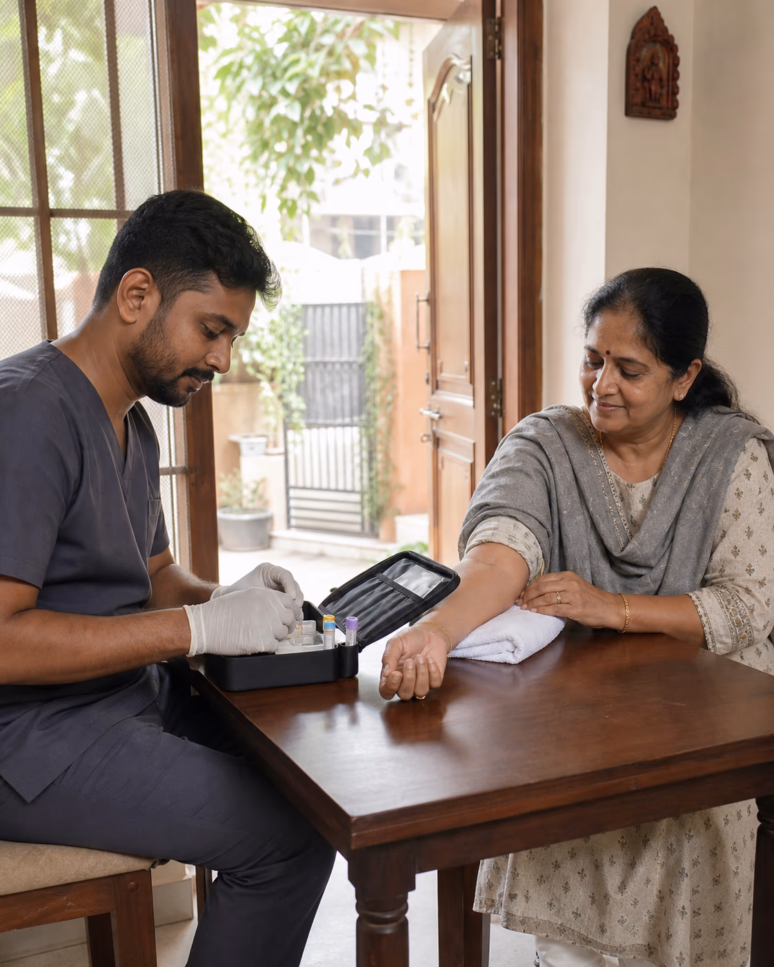 A phlebotomist preparing a routine blood sample across the table from a woman in her own home.